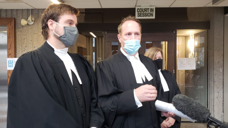 Senior Crown counsel Rick Woodburn (centre) comments on Justice Rosinski’s decision Monday outside the courtroom.