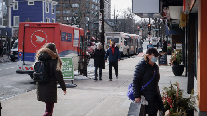 People walk down Spring Garden, one of Halifax's busiest streets. Businesses are operating on reduced capacity, and patrons must wear masks.