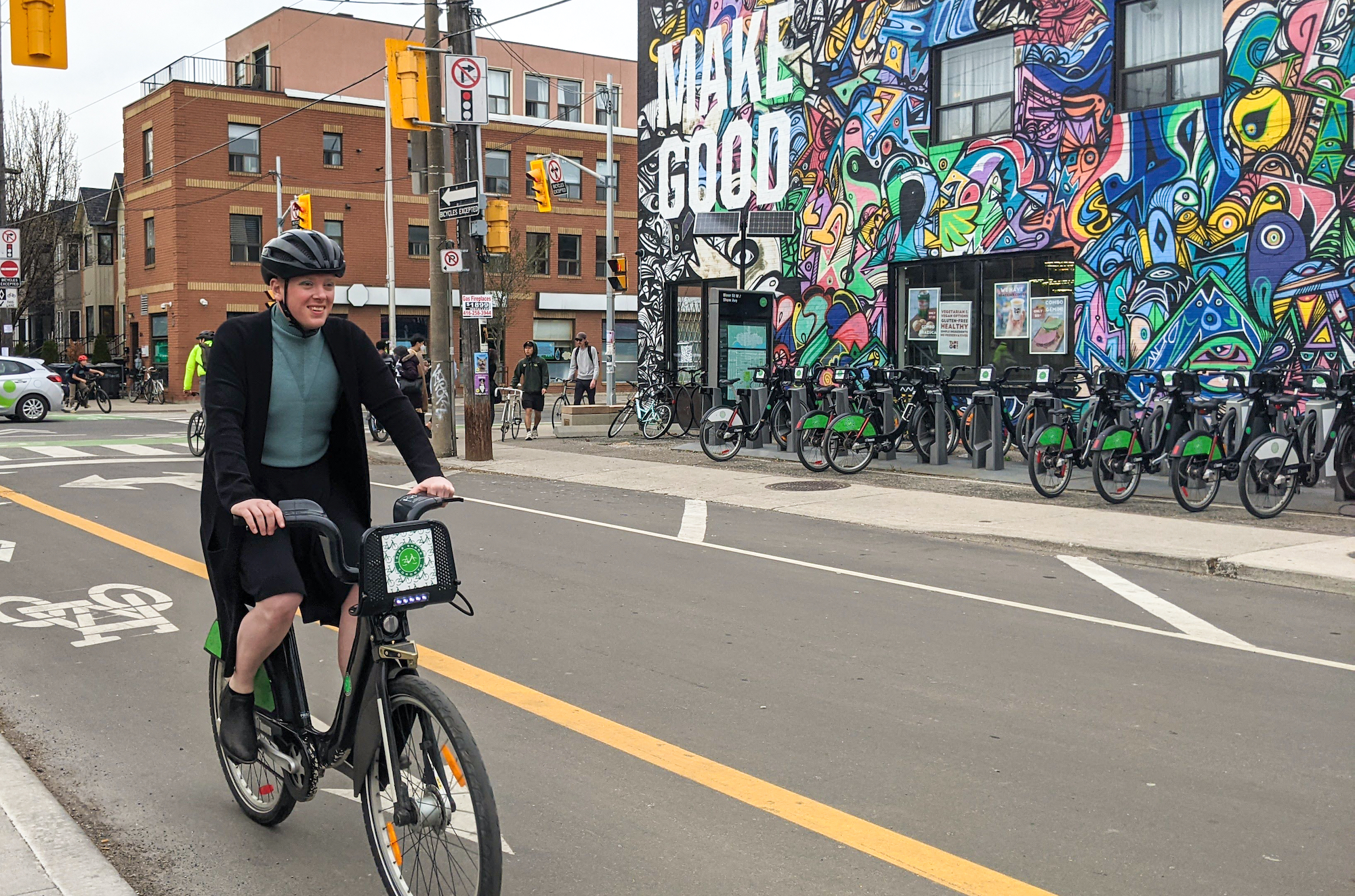 Riding a Bike Share bike in Toronto against a colourful mural