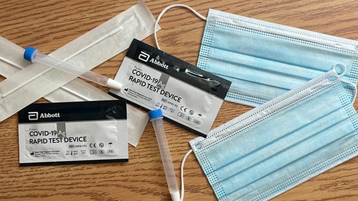 COVID rapid tests and masks lay out on a table. Three more people were reported Friday in Nova Scotia's intensive care units with COVID-19, bringing the current number to ten.
