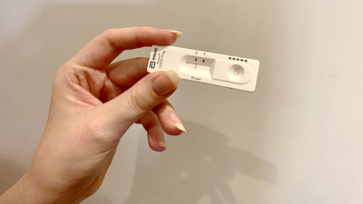 A woman shows a negative COVID-19 rapid test.