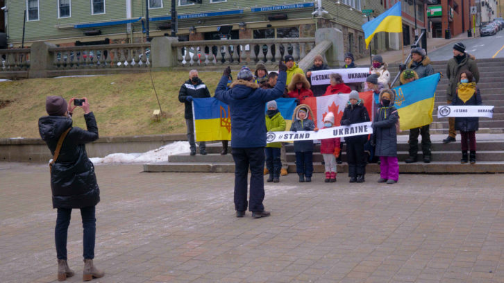 Andre Mereshuk, the president of the Ukrainian Canadian Congress’s Nova Scotia branch directs members and supporters of the Ukrainian community as they pose for a photo outside Halifax City Hall. 