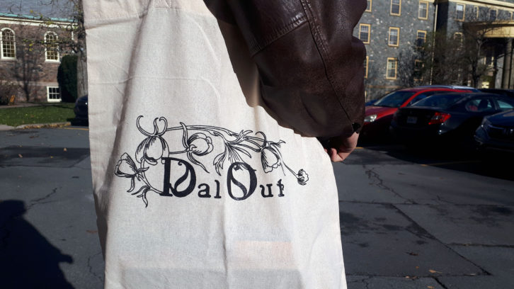 A person carrying a totebag with the DalOut logo on the front
