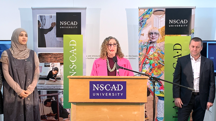 NSCAD President Peggy Shannon (centre) announces the university's deal with the Halifax Port Authority. Olivia Fay (SUNSCAD) and Captain Allan Gray (Port Authority) accompany (left to right). 