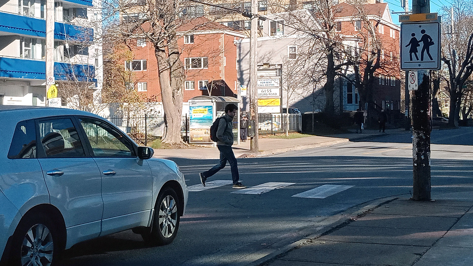 A pedestrian crosses Coburg Road on the crosswalk.