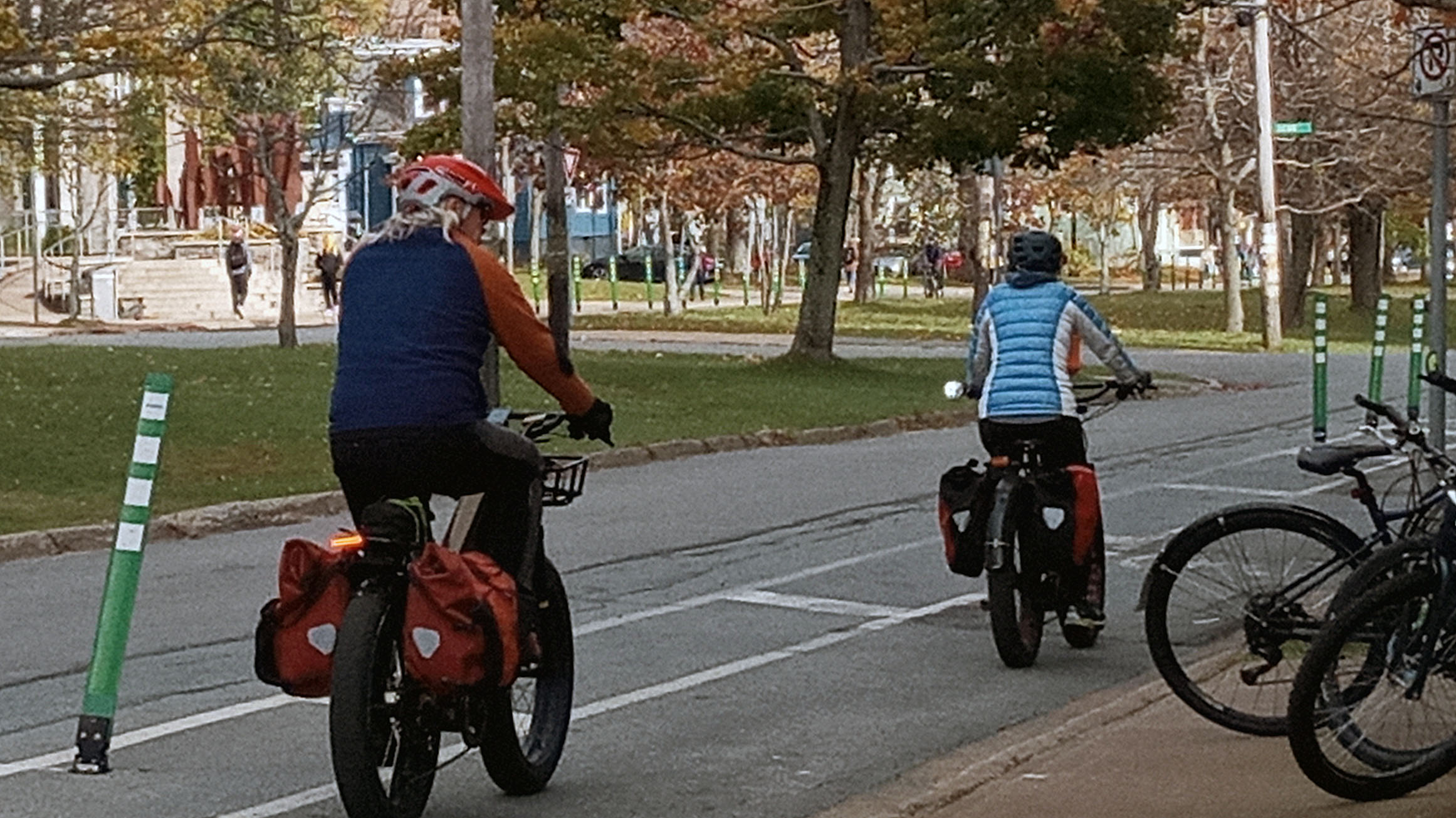 Two cyclists ride down University Avenue using the interim bike lane.