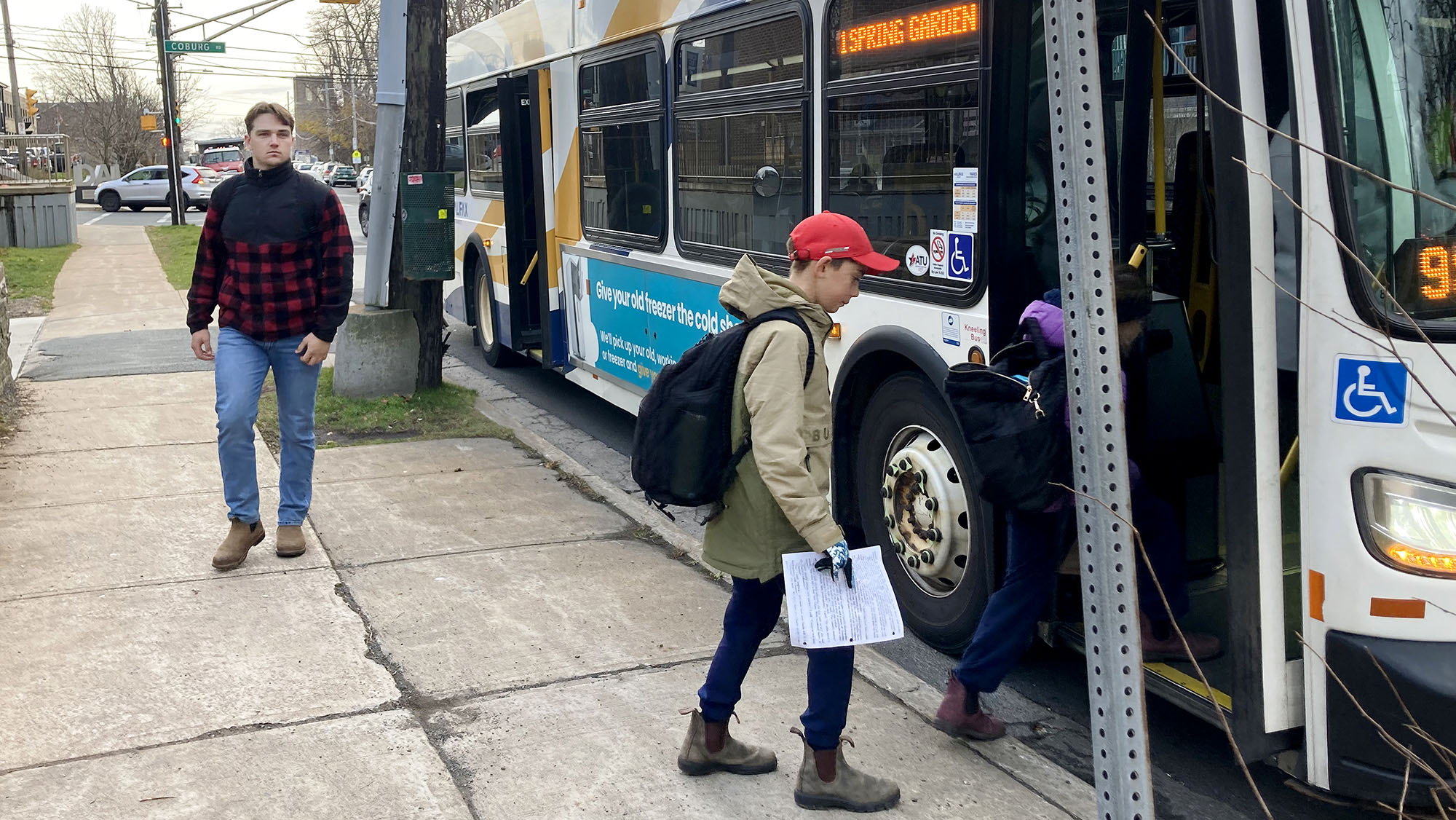 One person boards a Halifax Transit bus, while another leaves it