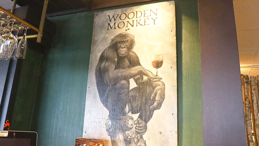 A painting showing a monkey holding a glass of wine. 