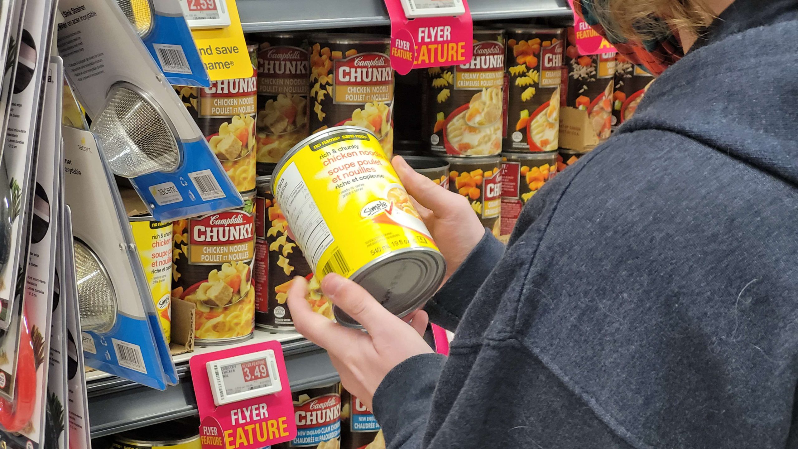 A shopper reaches for a can of soup from the grocery store shelves on a cold February morning.