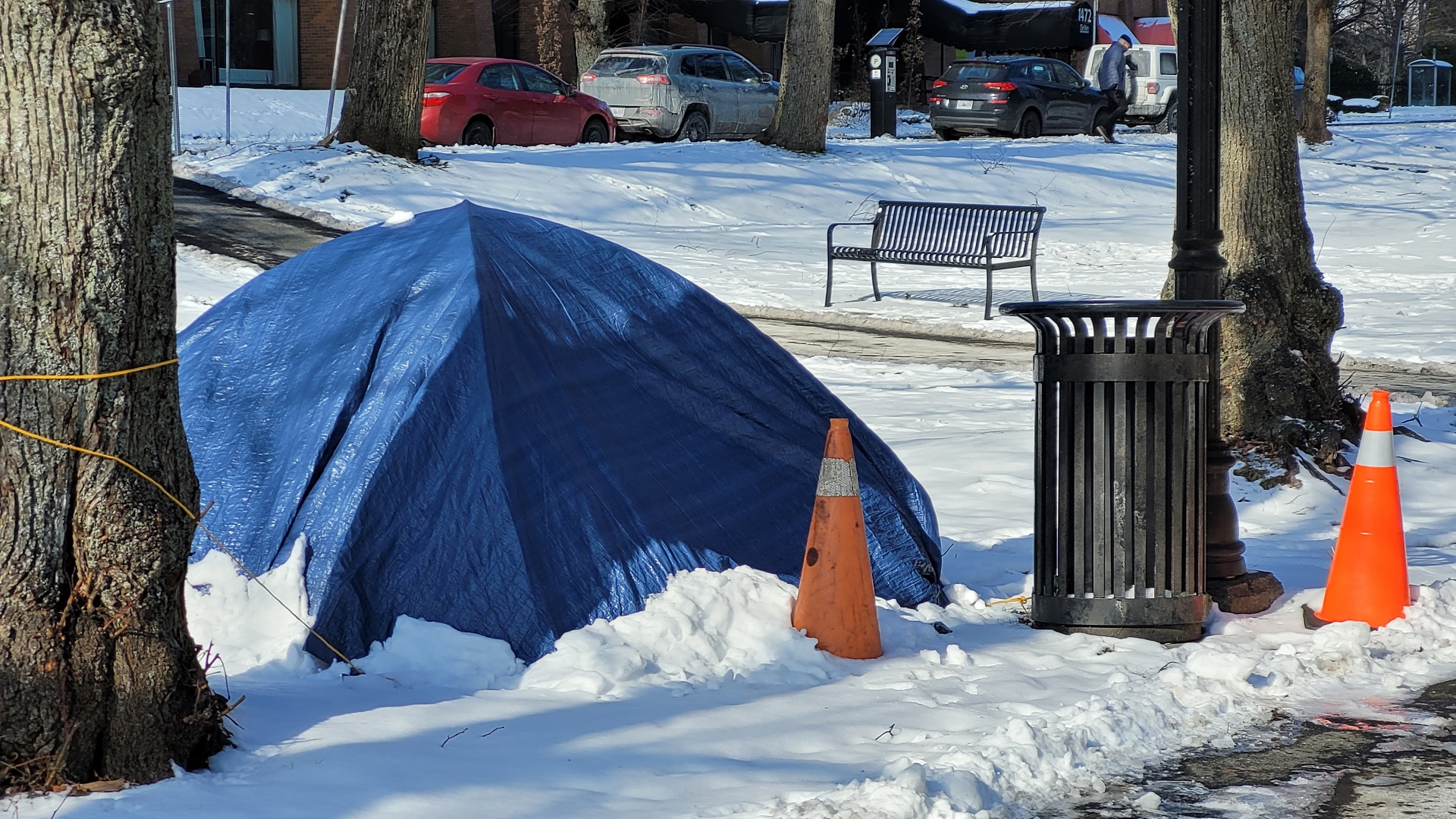 Tents are set up outside in a snowy city.