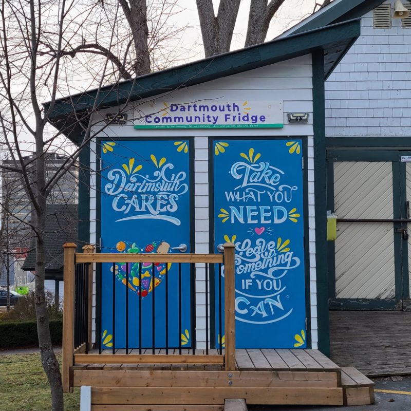 The Dartmouth Community Fridge has two doors. The left door, leading to the pantry, shows the painted words "Dartmouth cares." The right door, leading to the fridge, shows the words "take what you need, leave something if you can."