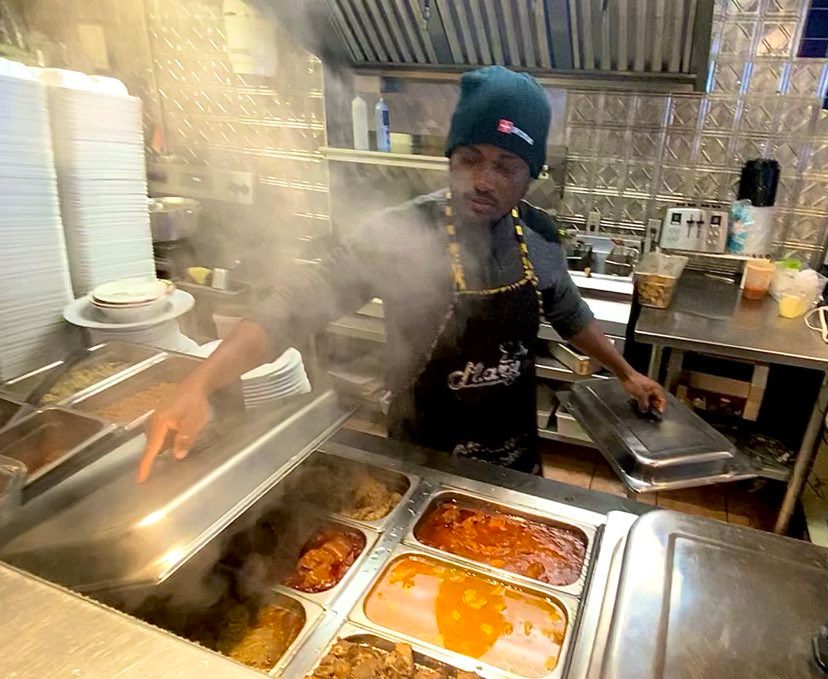 Man opens the lid of warm food in restaurant.