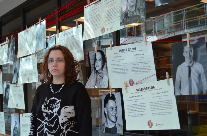 Mariia Lytvynchuk stands in front of Leah Krylova’s photo in the Unissued Diplomas exhibit at Saint Mary’s University in Halifax on March 19, 2023.