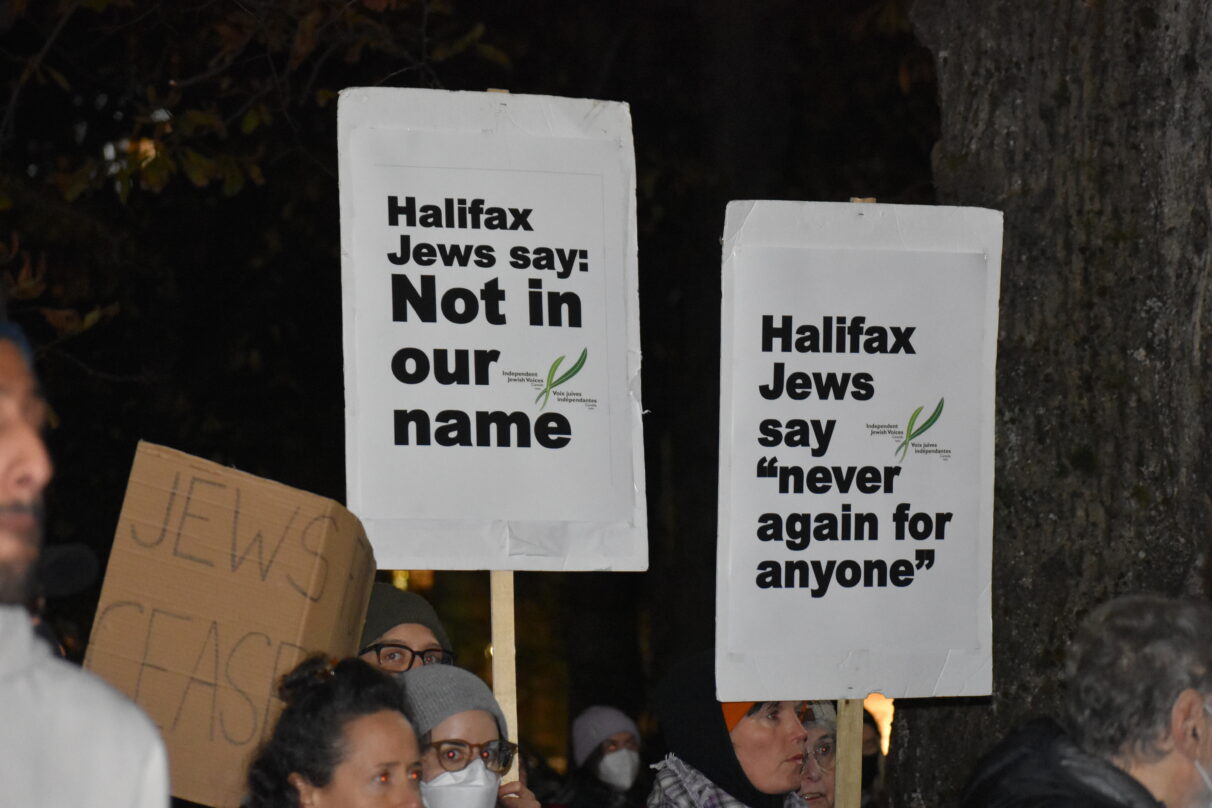 Two signs from Independent Jewish Voices with background and black writing.
