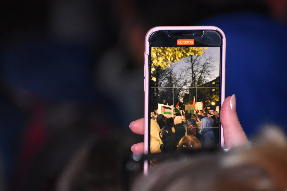A phone screen in focus, showing someone recording the rally.