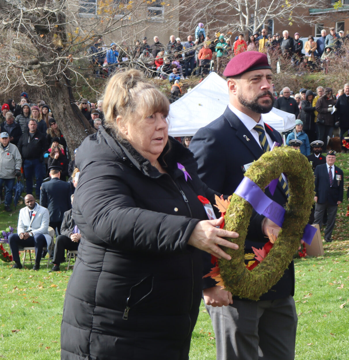 Danita Curwin carries a wreath to place on the wooden hanger in front of the cenotaph.