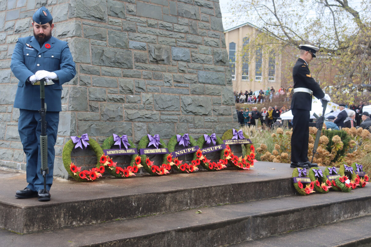 Soldiers stand on each corner of the cenotaph with their heads down during Remembrance Day 2023.