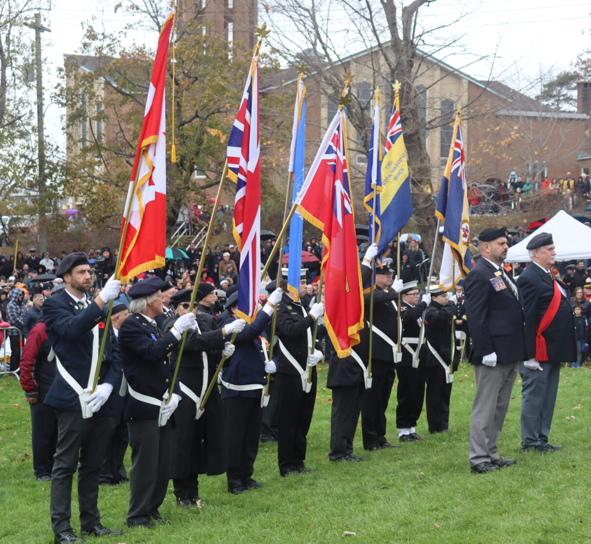 The flag bearers stand holding their respective flags.