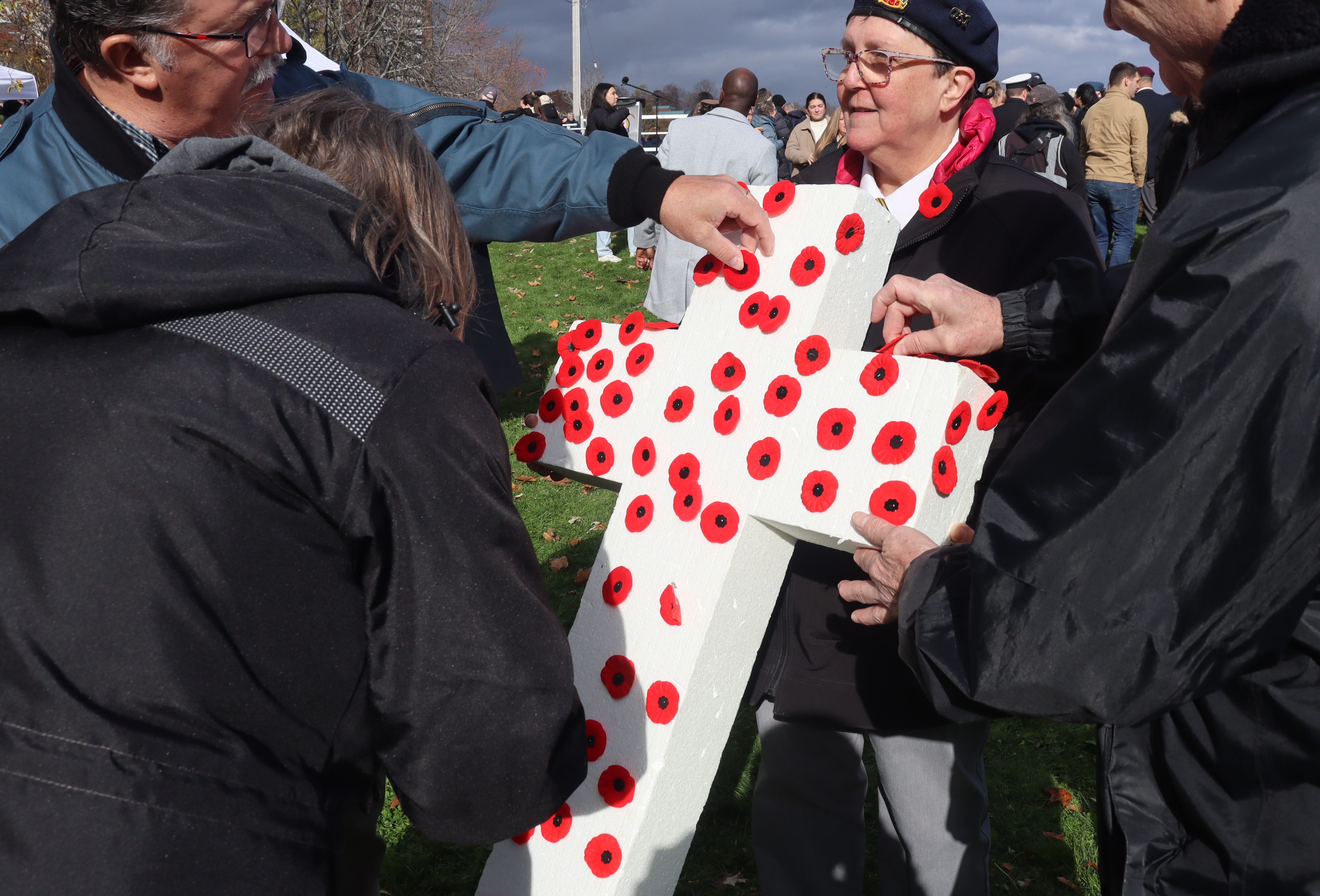 People place their poppies on crosses as the ceremony ends