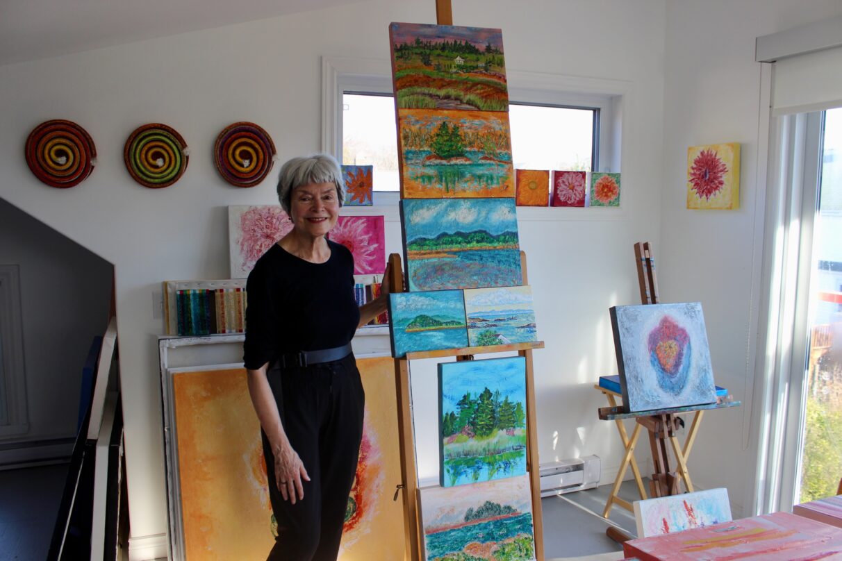 Artist poses with her art on display.