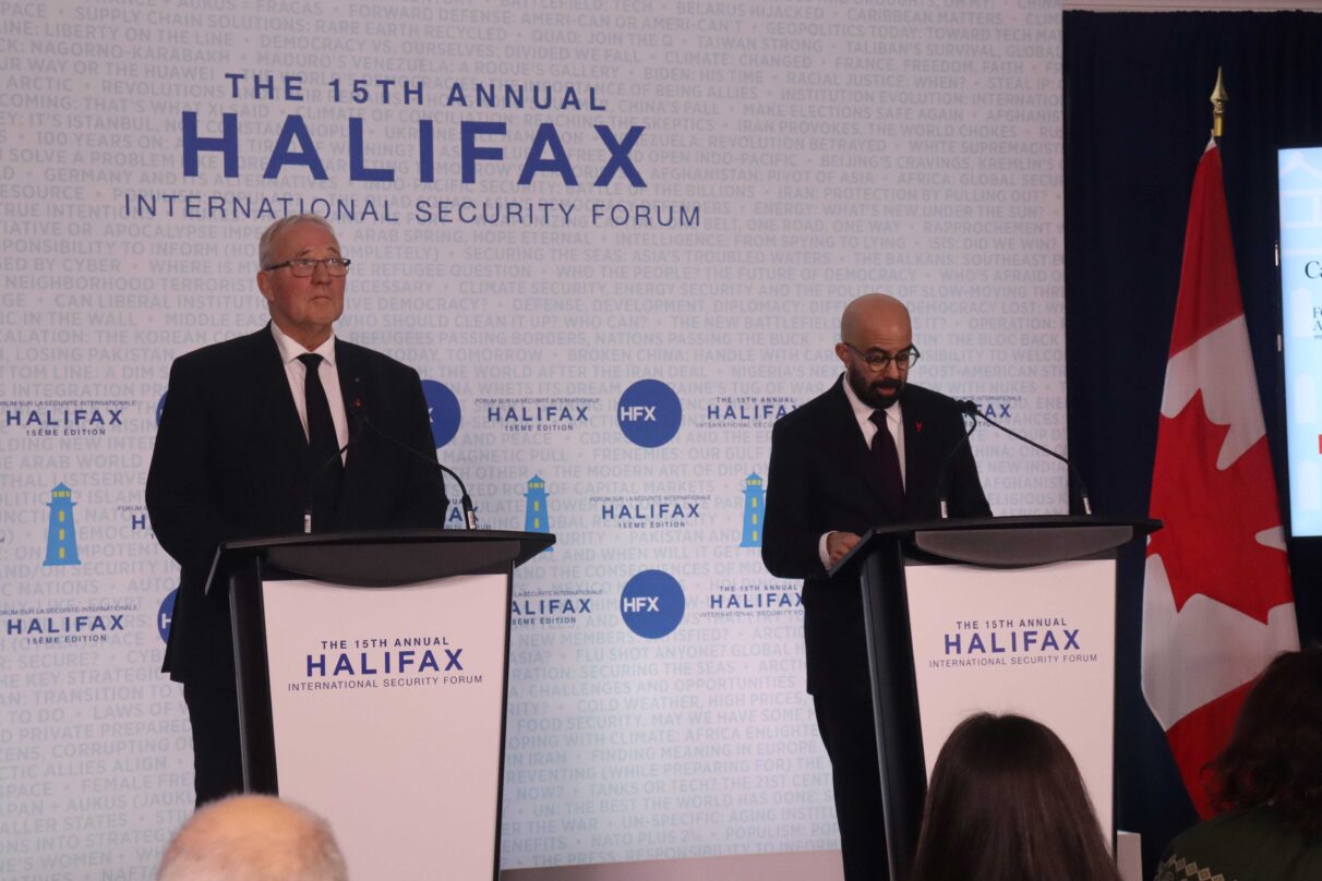 Two men at podiums speak at a conference in Halifax.