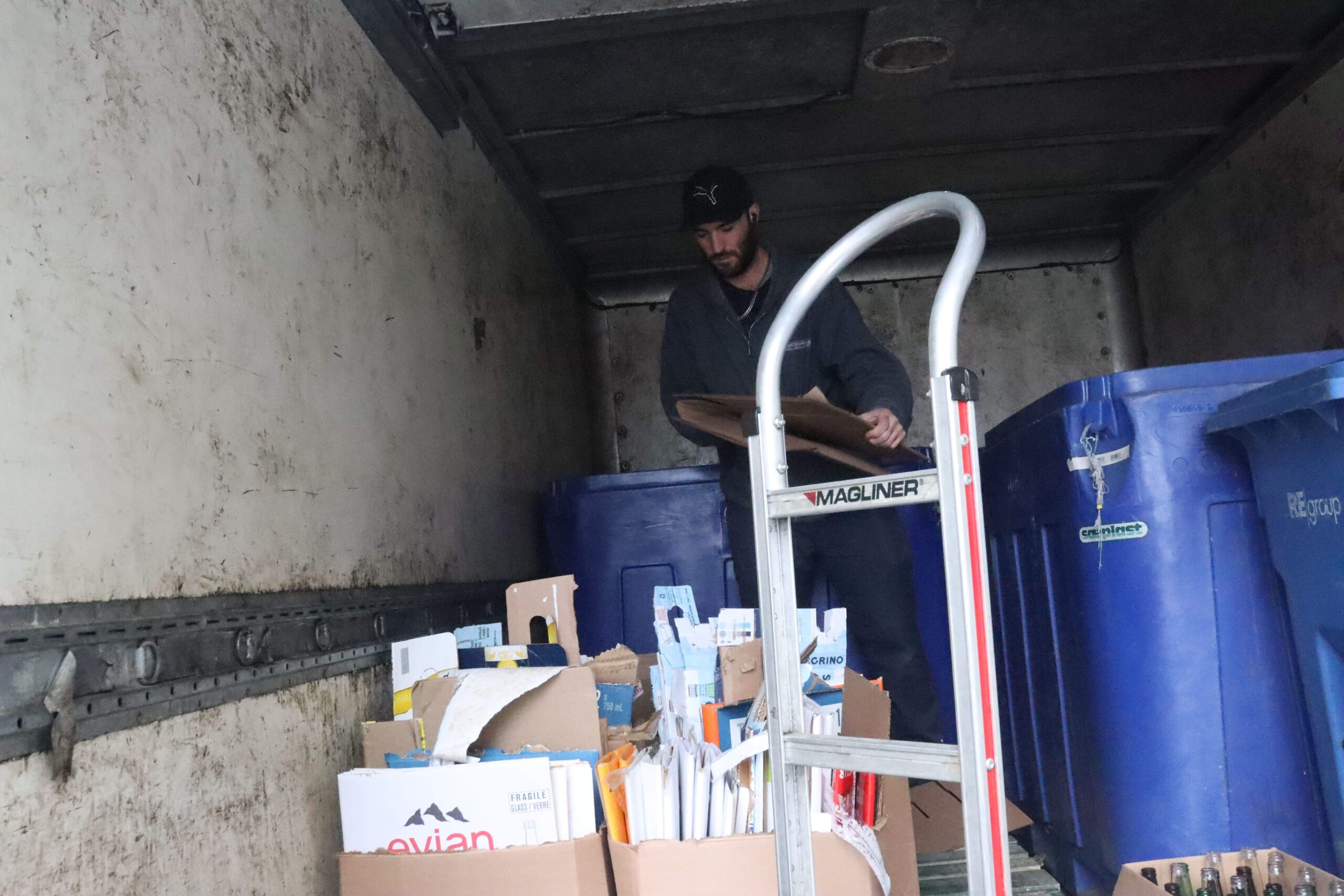 Recycling processor Daniel Moore breaks down cardboard boxes outside city hall.