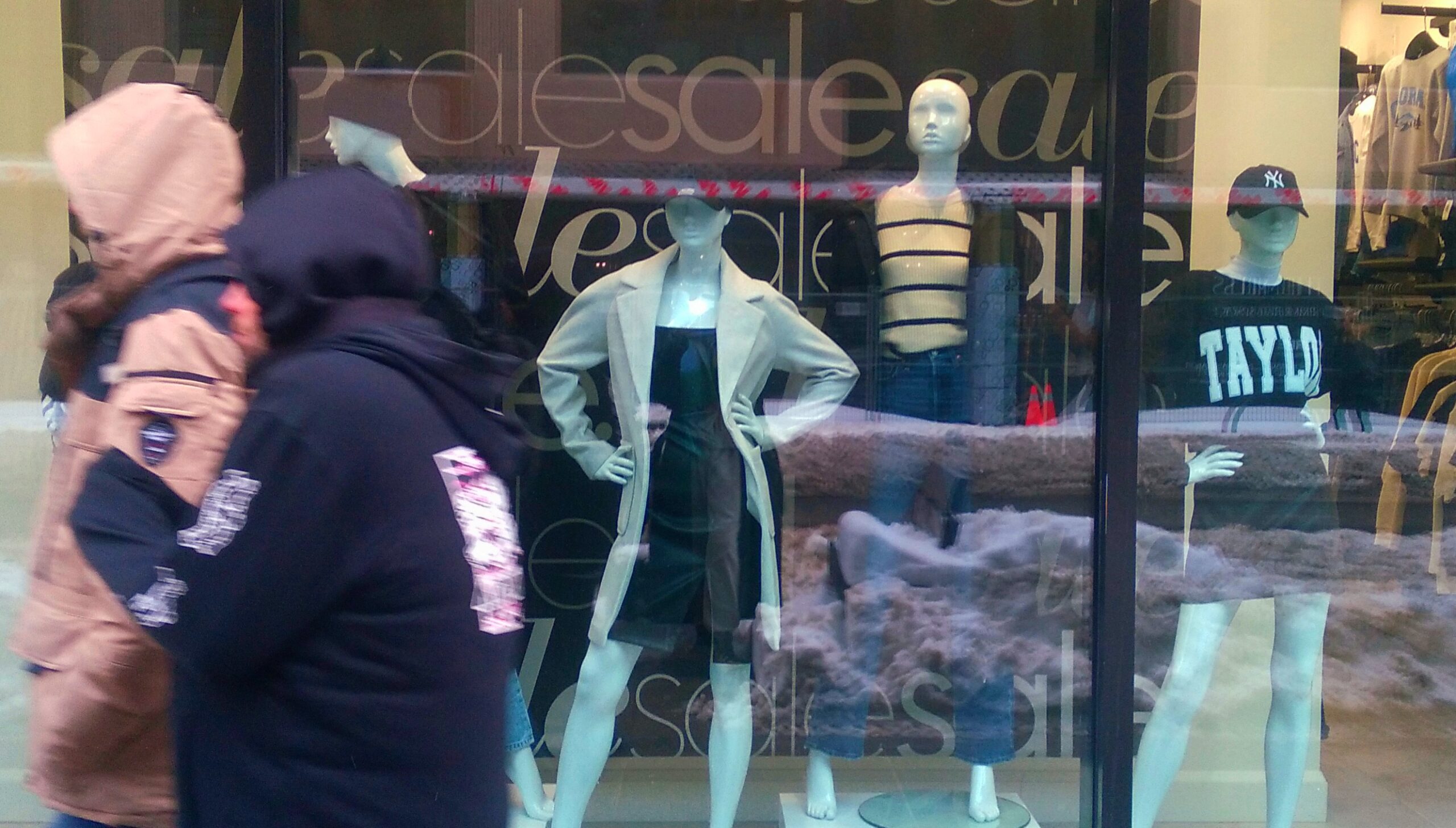 Store window displays Taylor Swift clothes.