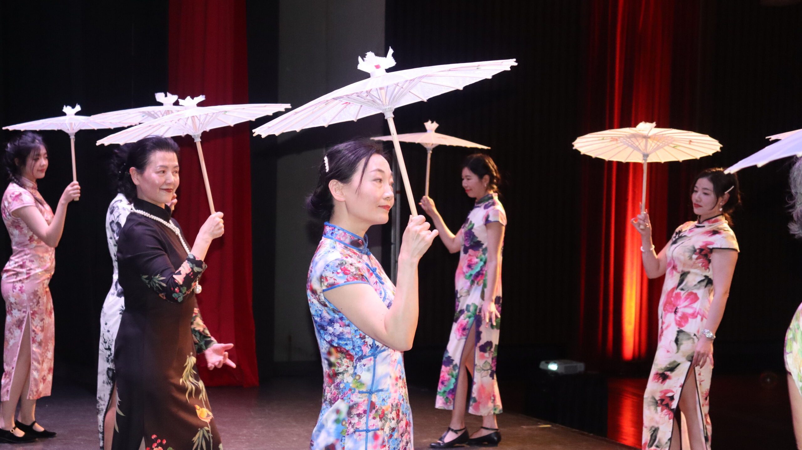 A group of women in cheongsam holding oil-paper umbrellas.