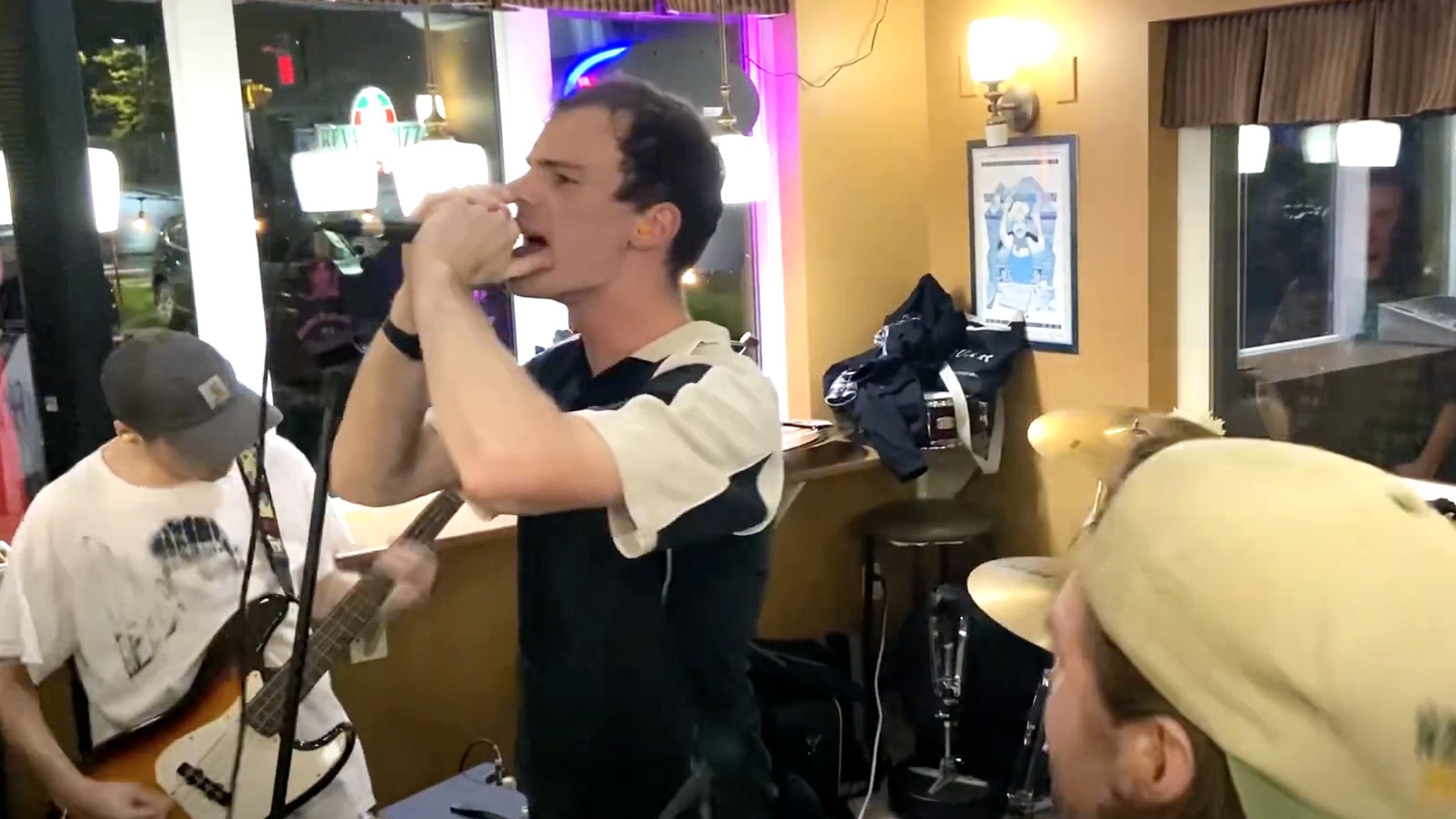 A band performs inside a pizza restaurant.