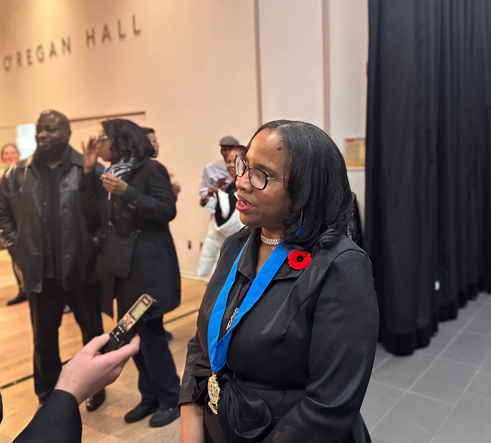 A woman being interviewed in an auditorium.