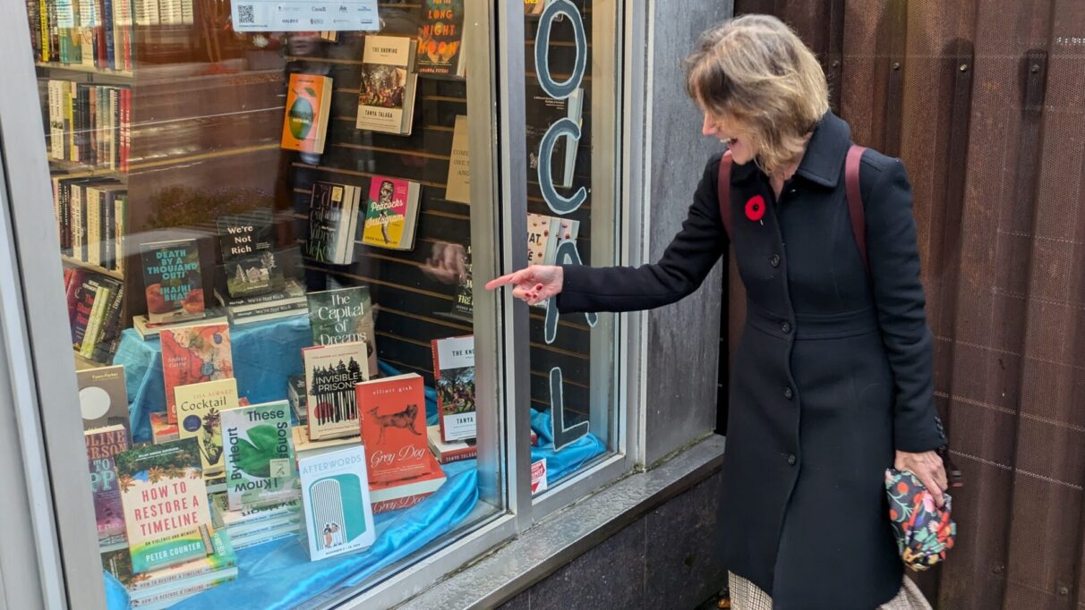 Author Lisa Alward points to a copy of cocktail on a store shelf