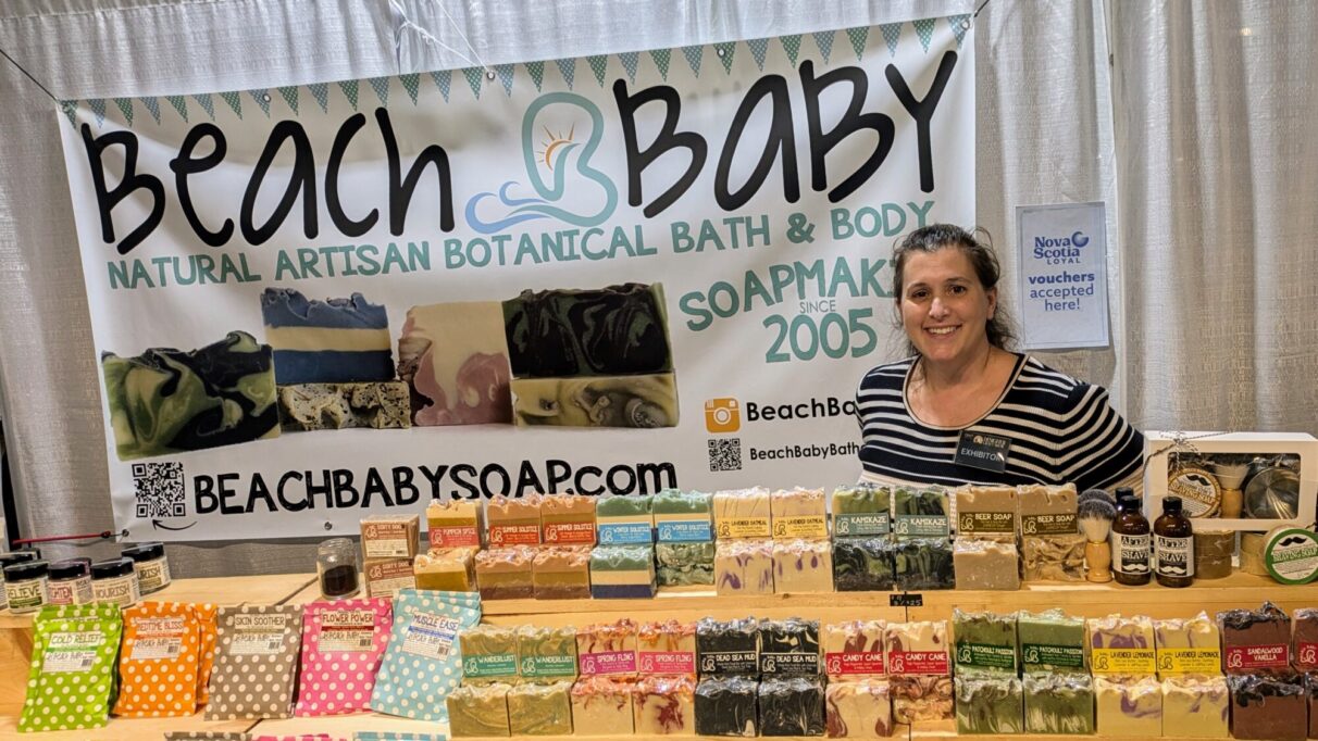 Jessica Scott stands in her Beach Baby booth with her soaps displayed in front of her