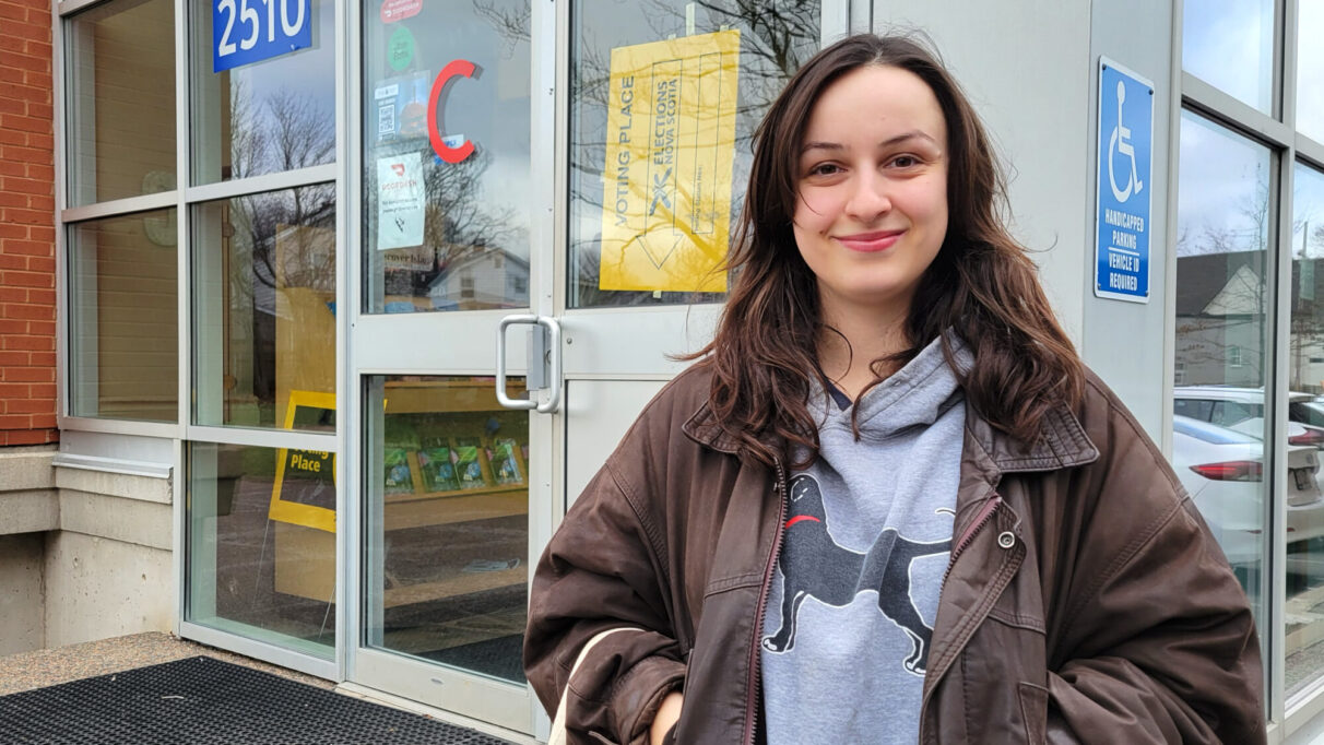 a woman stands in front of a building