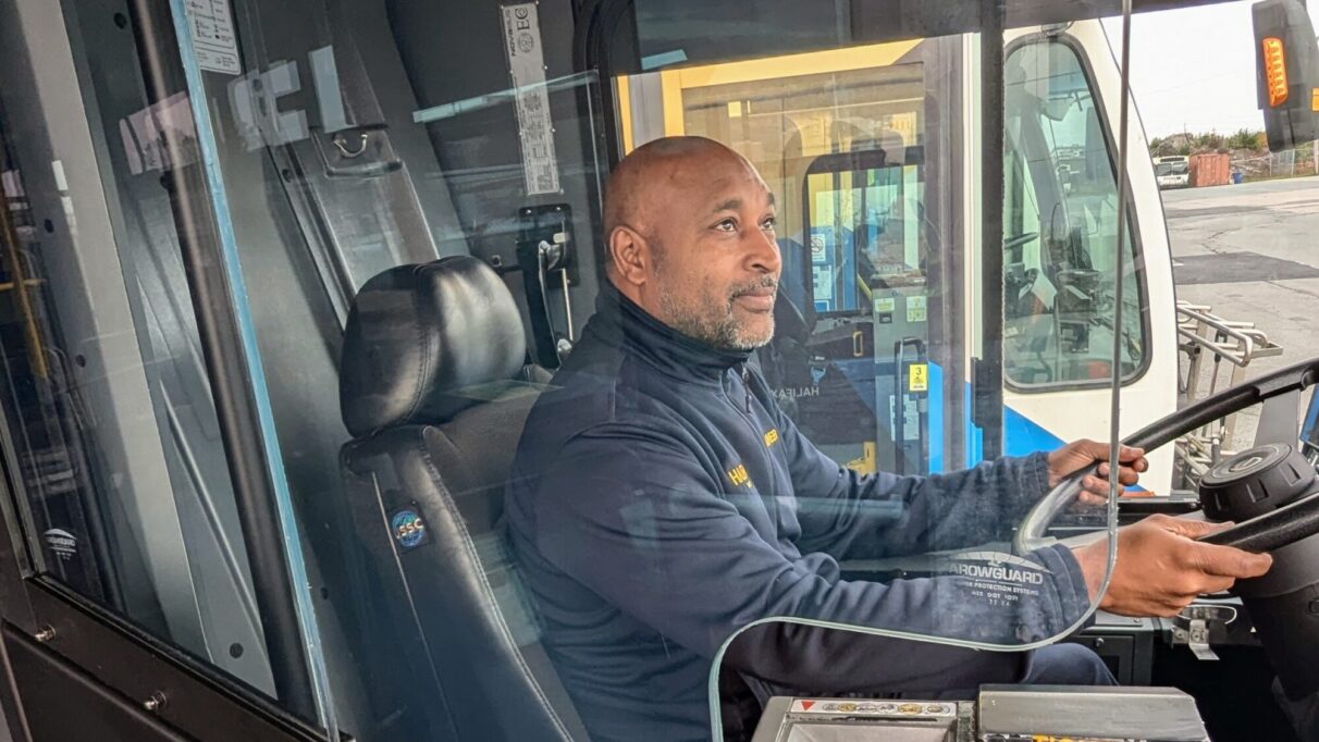 A bus driver behind a shield.