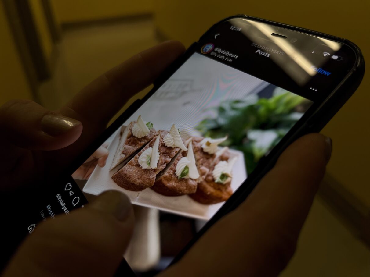 A person scrolling through the Dilly Dally's Instagram page. A picture of pear and chai loaf. 