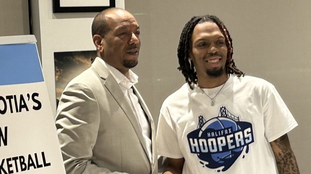 A player and owner shake hands following a contract signing.