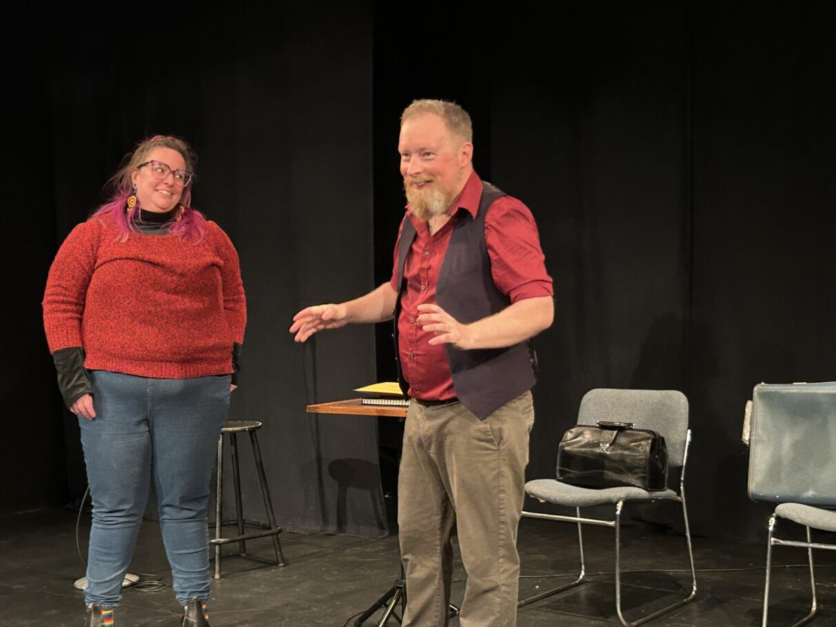 Bill Wood is joined on stage by a volunteer from the audience in order to assist him with a trick.