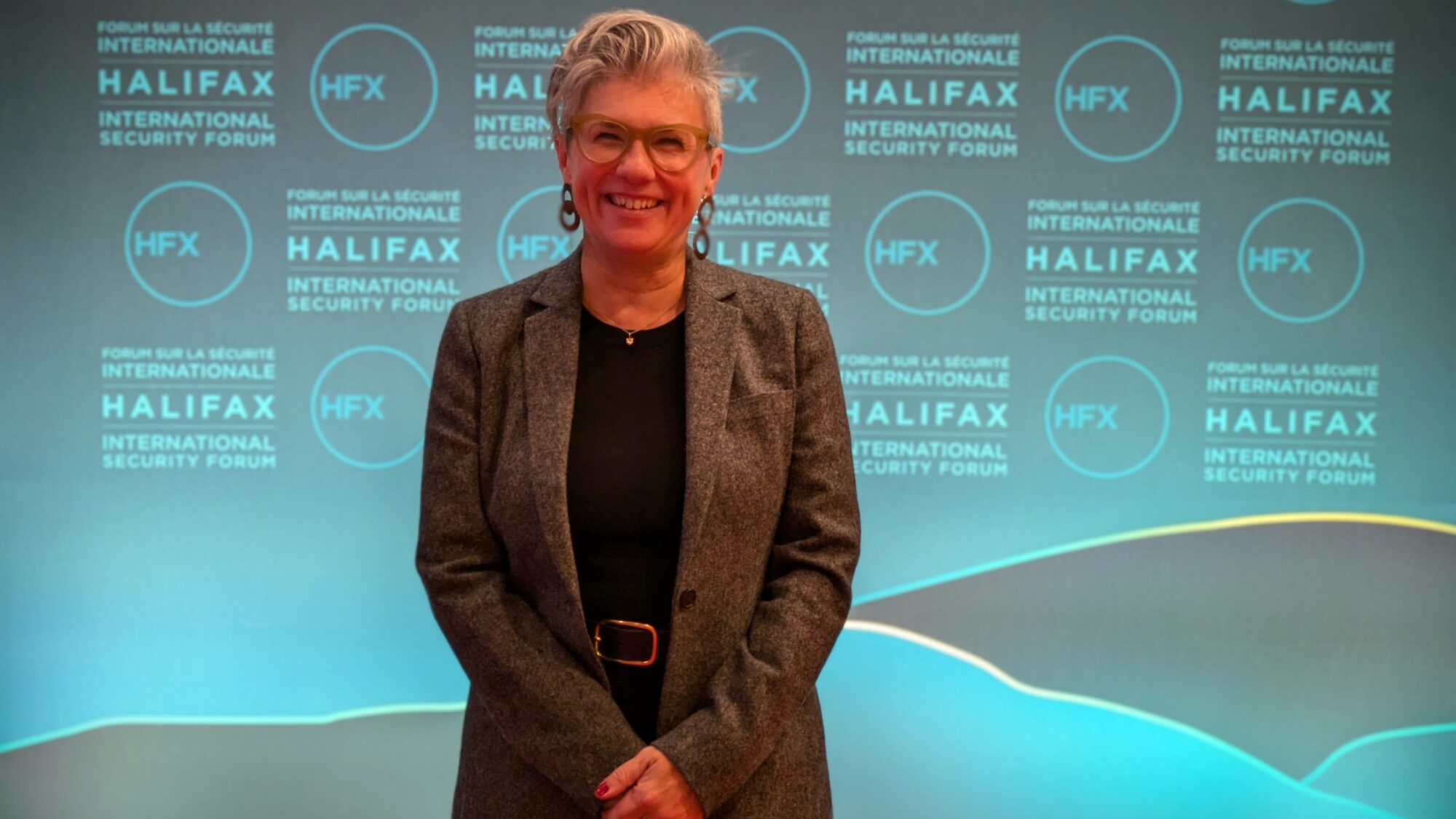 Canada's ambassador to Ukraine, Natalka Cmoc, smiles in front of a Halifax International Security Forum photo backdrop