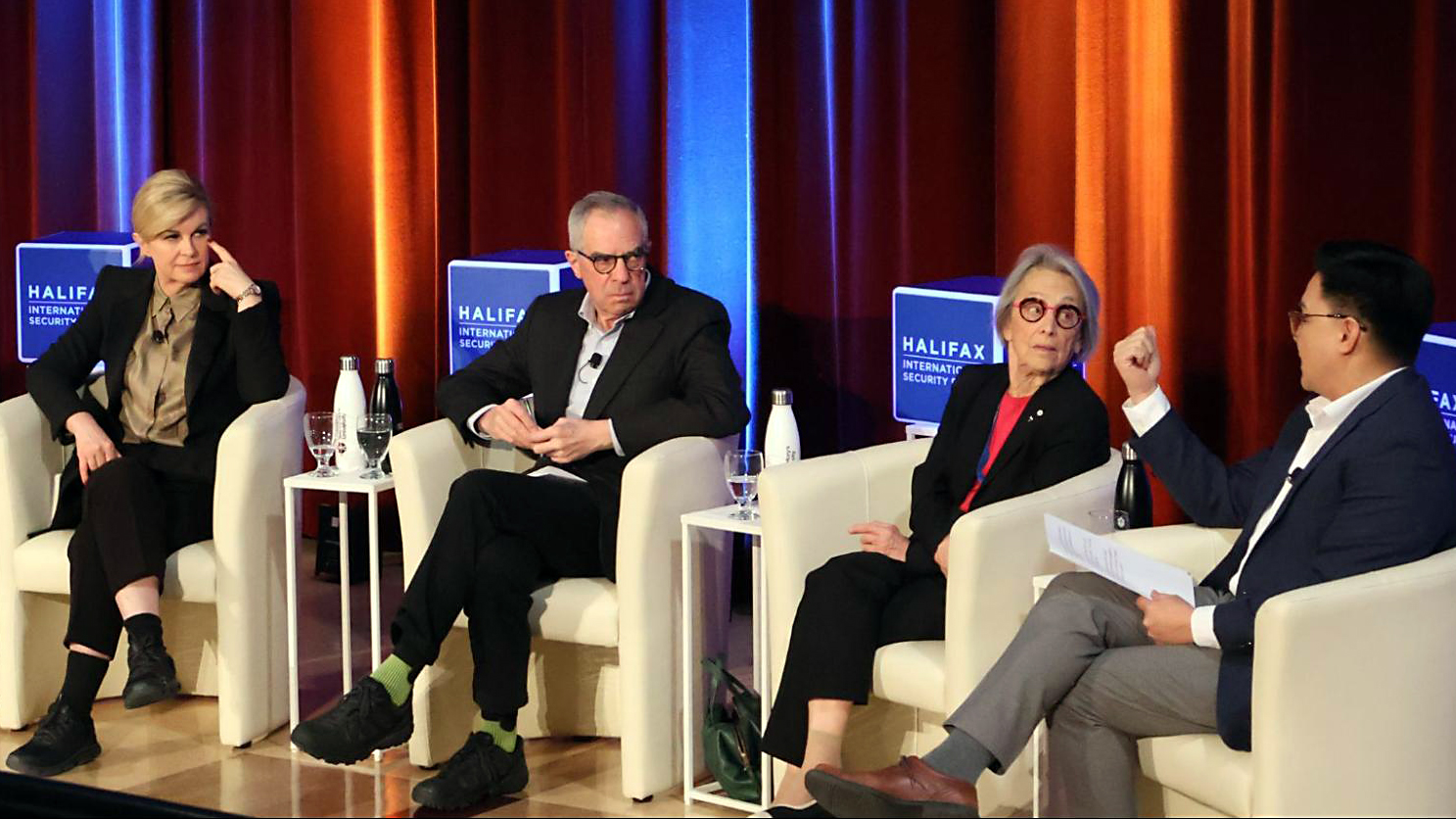 Four panels in chairs engage in a discussion