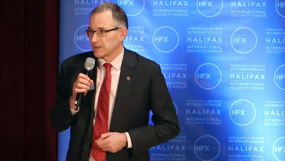 Man with microphone in front of blue backdrop