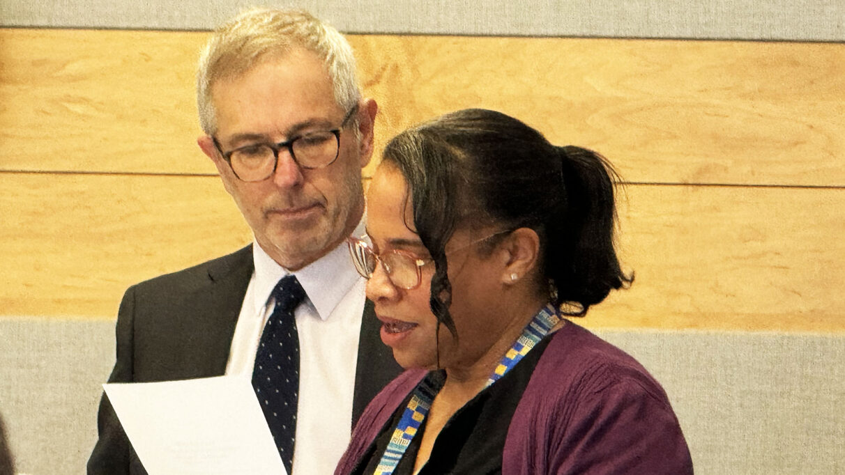 A man and a woman reading from a paper