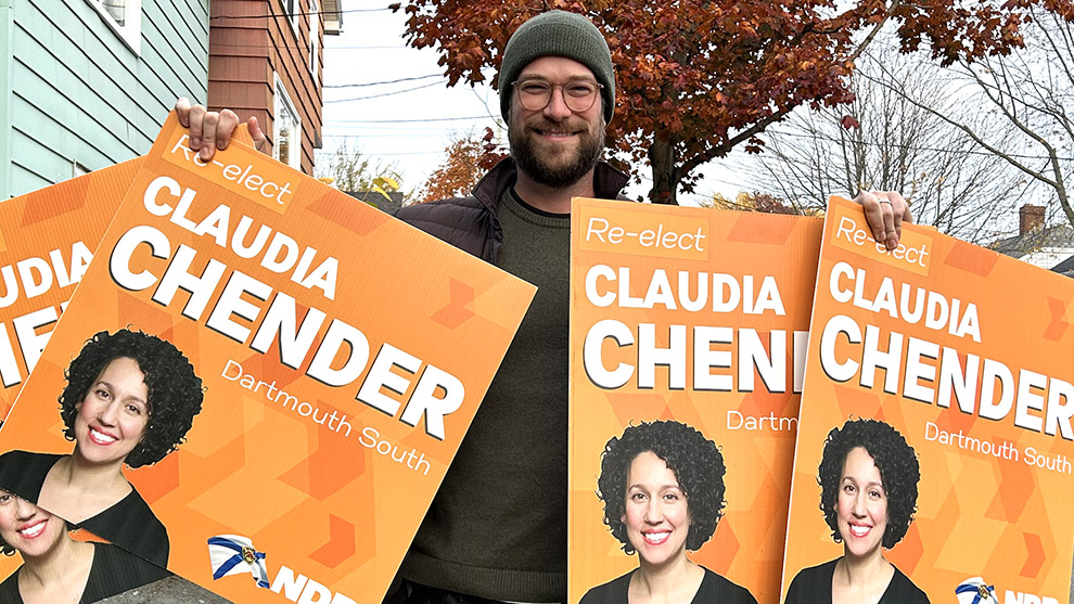 Man holding four campaign signs