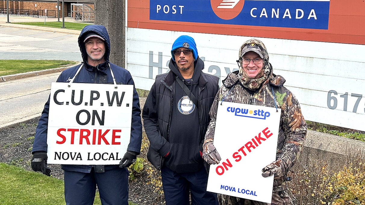 Three men standing, two wearing signs