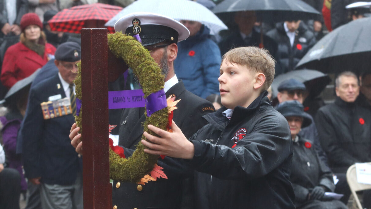 a young person lays a wreath