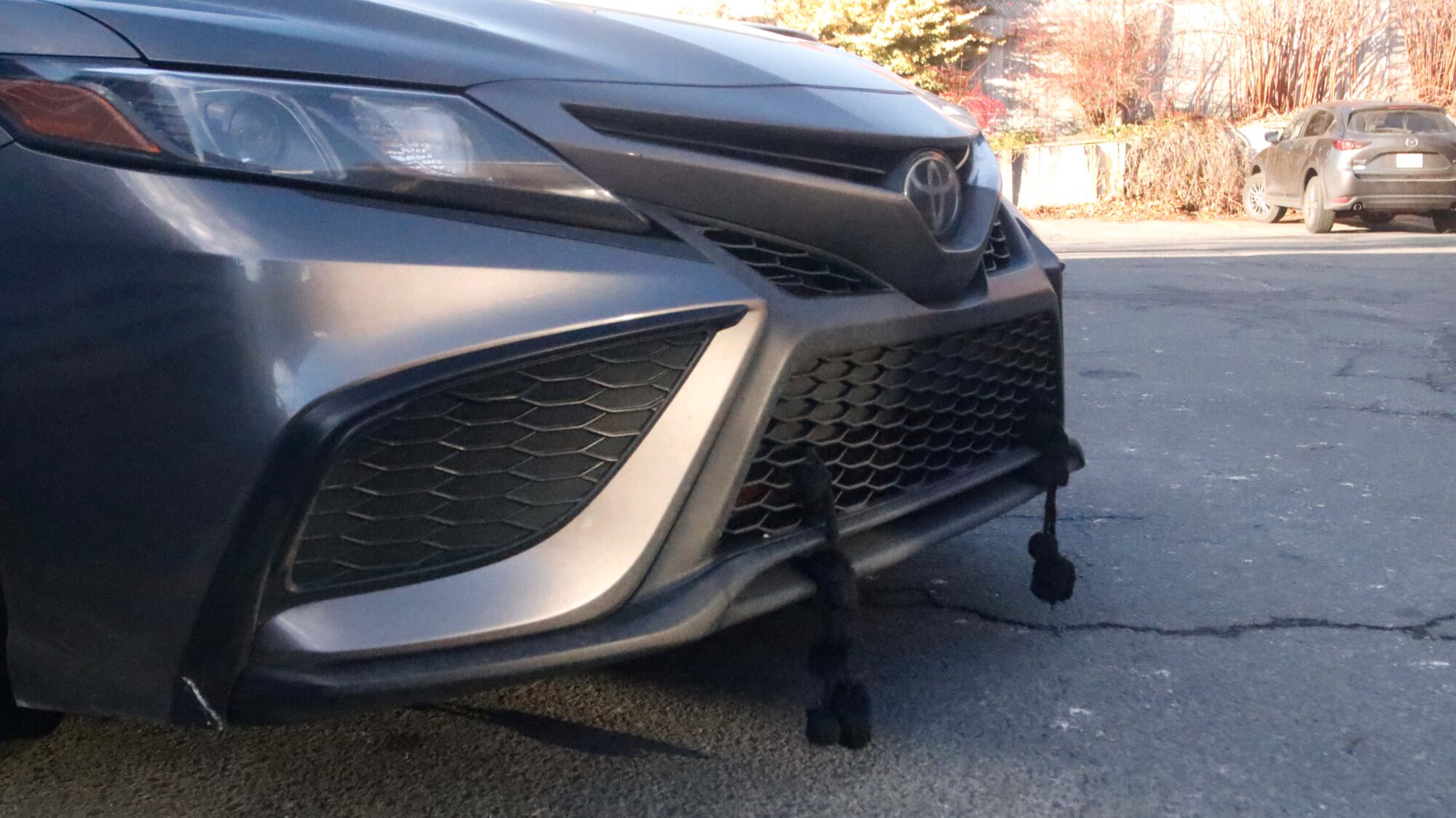 a car with black tassels hanging from the front bumper