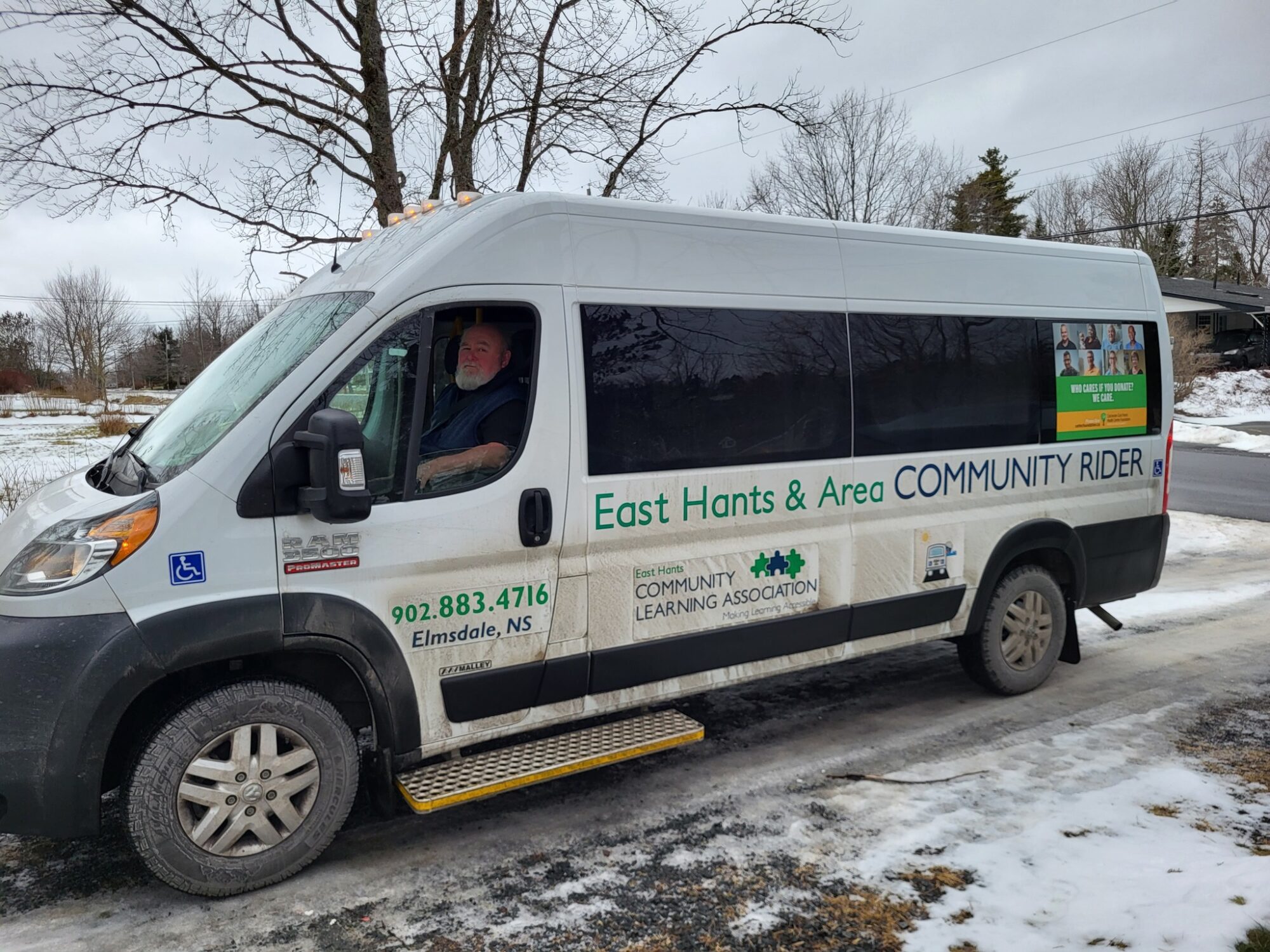 A white van with man sitting in drivers seat.