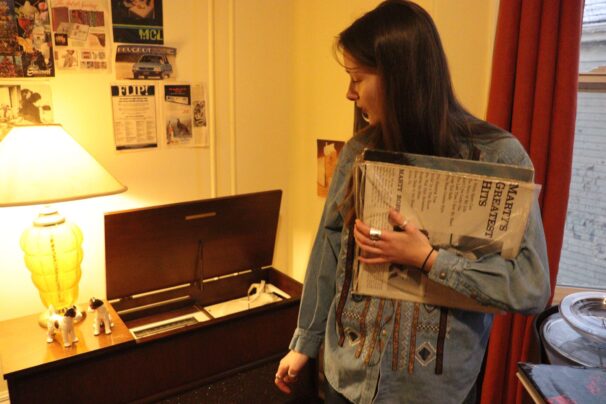 person holding records in front of a record player