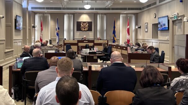 A group of people sit in the audience in council chambers, facing the Halifax Regional council.