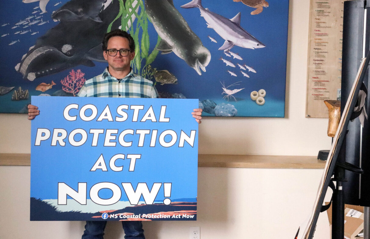 Nicolas Winkler holds a sign calling for the proclamation of Nova Scotia’s Coastal Protection Act during at the Ecology Action Centre in Halifax, N.S.