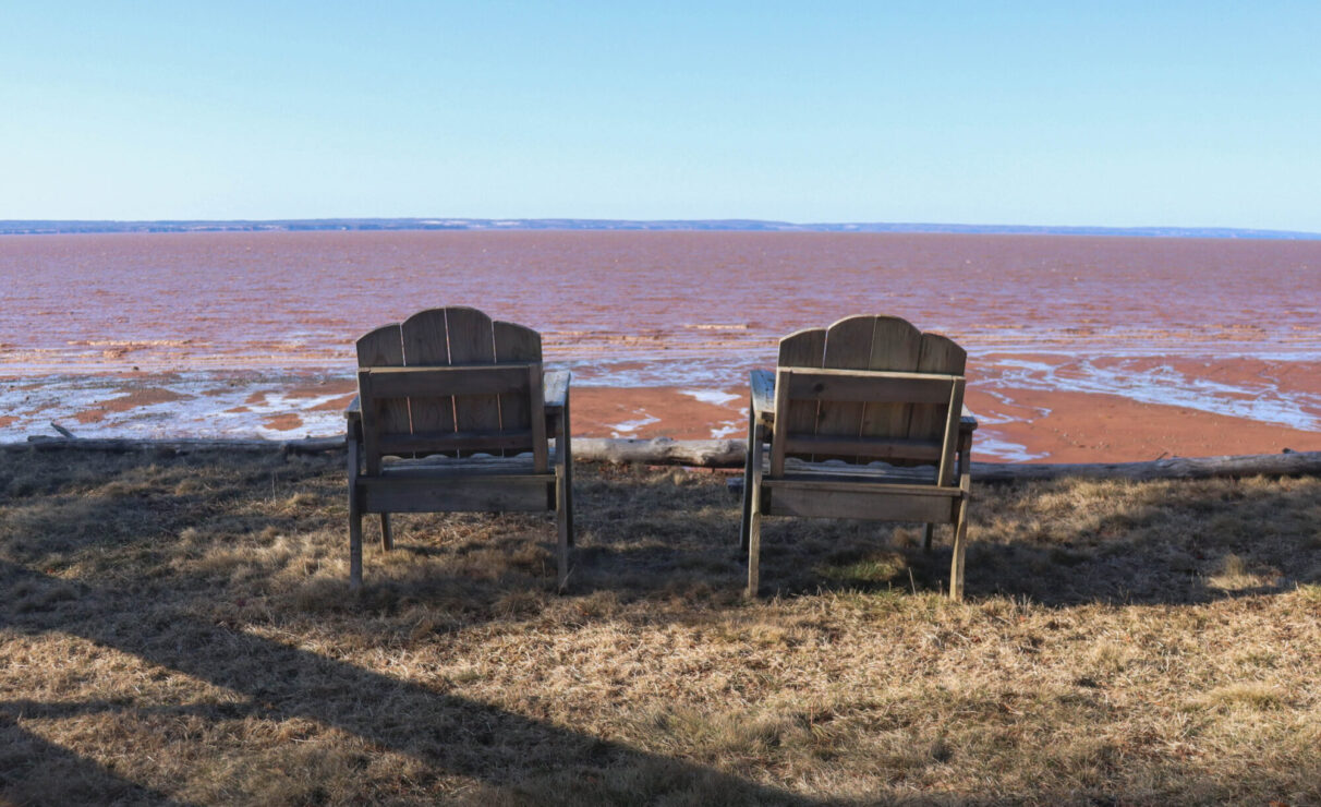 Two wooden chairs face the Cobequid Bay outside Ralph Wardrope’s cottage in Bass River, N.S.